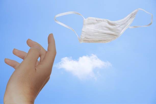 istock Remove the mask and throw it away towards the blue summer sky 1264512551