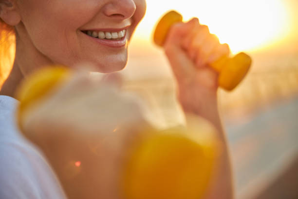 istock Joyful female athlete doing an arm exercise with dumbbells 1264515855