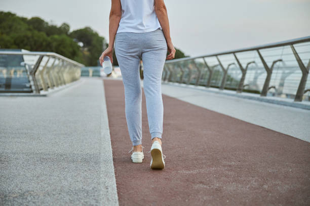 istock Female with a plastic bottle walking ahead 1264515939