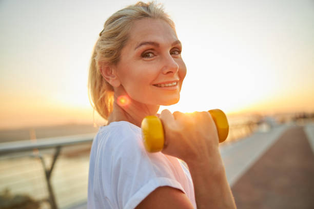 Sporty lady standing on a bridge during the training