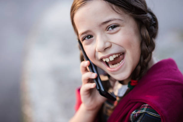 Silly young child using phone and smiling