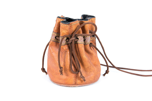 Old leather drawstring bag with brown string tied isolated on white background. Small old brown leather drawstring bag isolated