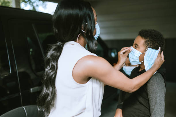 istock Mother Helps Child Put on Face Mask Correctly 1264525576