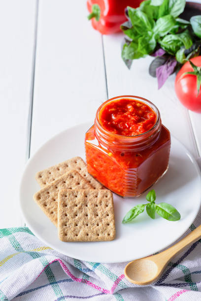 plato tradicional balcánico ajvar, lutenitza, pingjur, con pan sobre un plato sobre mesa de madera blanca - chutney jar tomato preserved fotografías e imágenes de stock