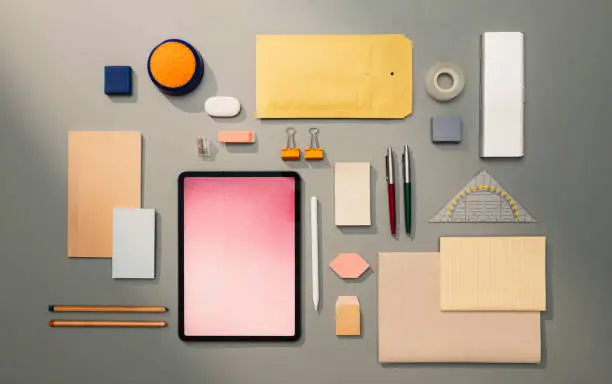 Office/school supplies: a flat lay composition including pens, pencils, notebooks, and other work/study-related objects, including technology.