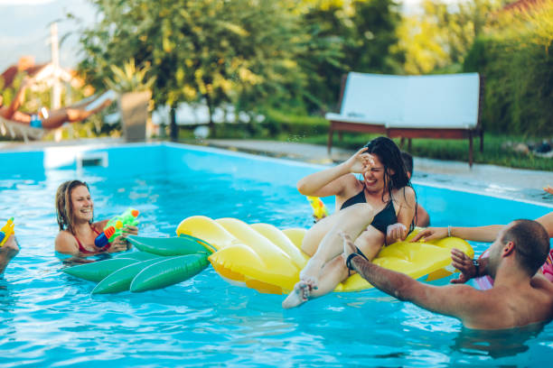 istock Friends water fight in pool 1264533526