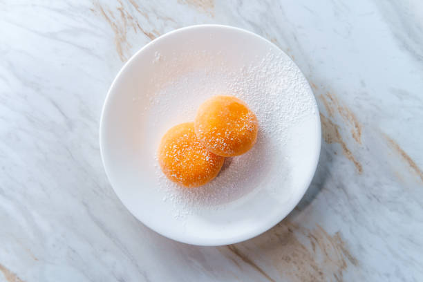 Traditional Japanese orange mochi ice cream on marble kitchen table