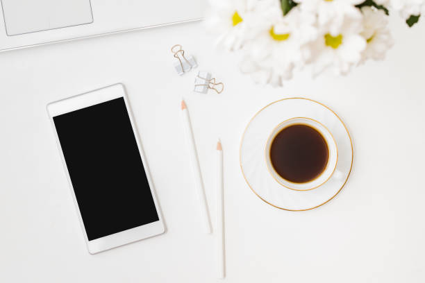 istock Flat lay mockup smartphone blank screen, laptop a cup of coffee on a white background 1264535435