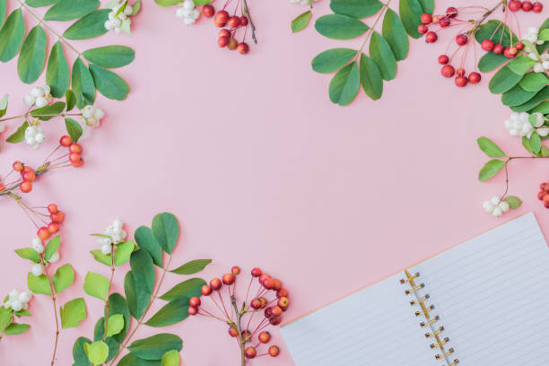 istock Flat lay autumn composition with green leaves, open notebook and small red apples on a pink background 1264535441