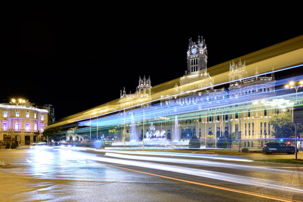 madrid nachtfoto waarin we de plaza de cibeles, de puerta de alcala, het stadhuis, la casa de america en het verkeer van auto's en bussen kunnen zien - casa de america madrid stockfoto's en -beelden