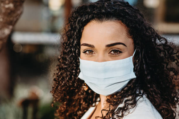 istock Smiling woman behind face protection mask 1264535553
