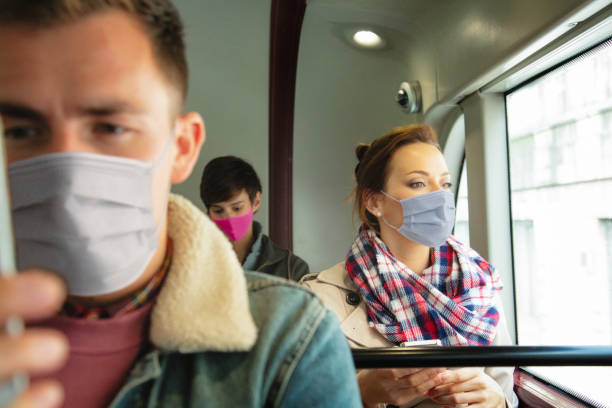 istock Three young people wearing face covers and social distancing during a bus ride 1264536279