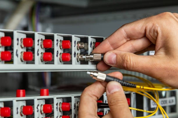 istock A man inserts a yellow black fiber optic cable into a switch. Hands close up. Horizontal orientation 1264539903