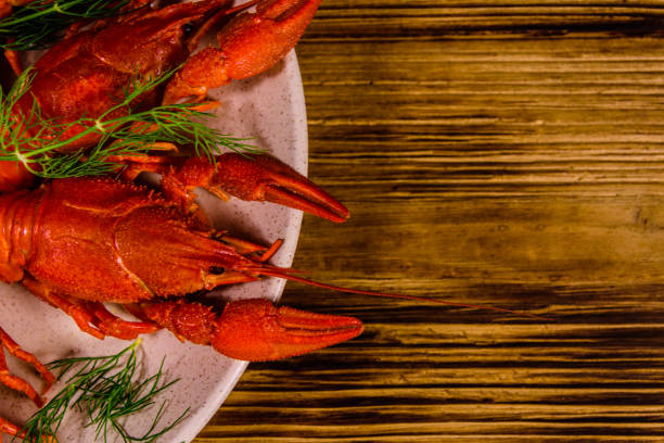 istock Plate with boiled crayfishes on wooden table. Top view 1264542161