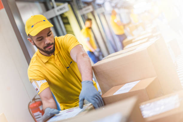 istock Distribution center worker handling cardboard packages 1264545083