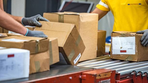 istock Close-up photo of postal office workers handling packages 1264545091