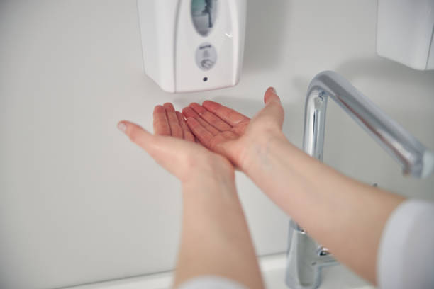 istock Close up of hands pouring down disinfector 1264546313