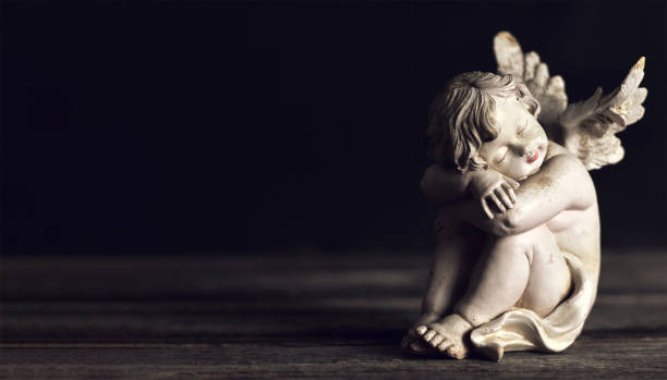 istock Angel sleeping on dark wooden background with copy space 1264547335