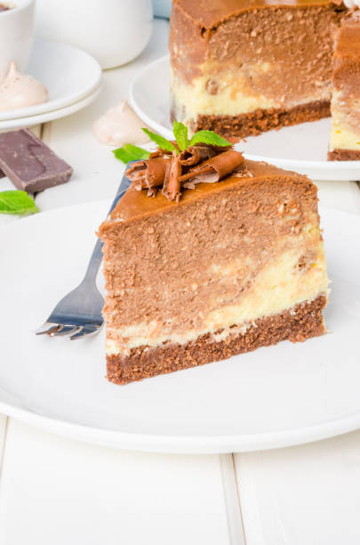 istock Marble chocolate coffee cheesecake with meringue, marshmallow and chocolate on top on white wooden background. 1264548133