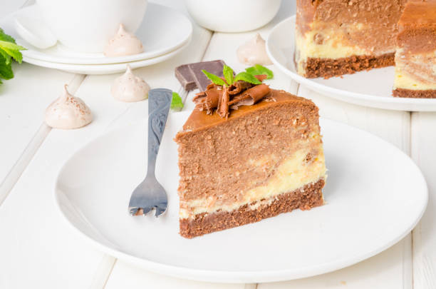istock Marble chocolate coffee cheesecake with meringue, marshmallow and chocolate on top on white wooden background. 1264548145