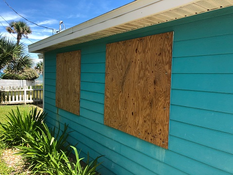 Homemade plywood covers the windows of a beach cottage in Florida in preparation for an oncoming hurricane.