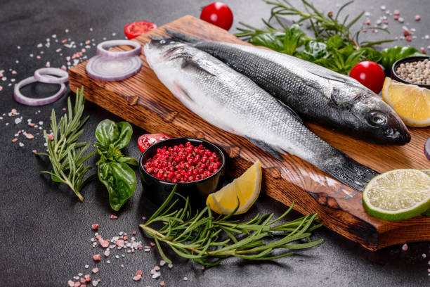 istock Raw fish seabass with spices and herbs on a dark table 1264548519