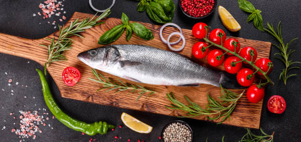 istock Raw fish seabass with spices and herbs on a dark table 1264548539