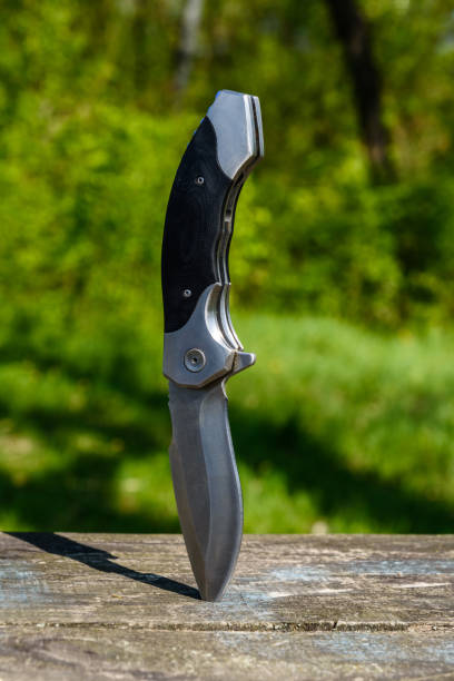 istock Folding knife stuck in the old wooden board 1264549532