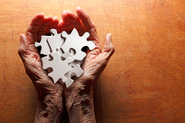 istock Aging Woman's Hands Holding Puzzle Pieces 1264550828