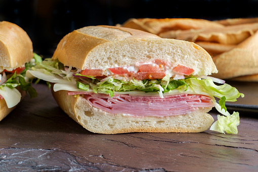Italian sub sandwich with ham and genoa salami on slate kitchen table