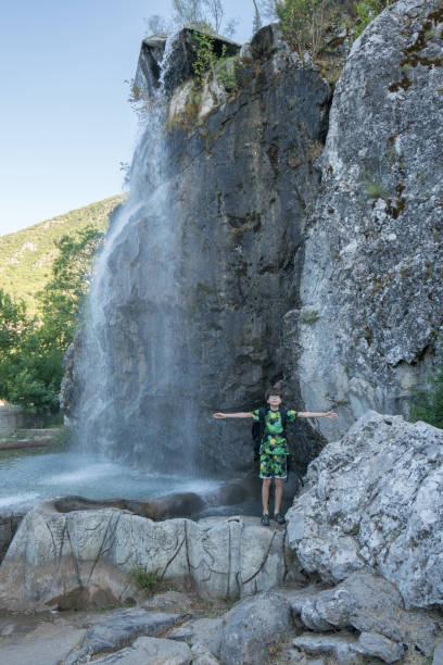 istock Happy boy enjoying by the waterfall 1264552276