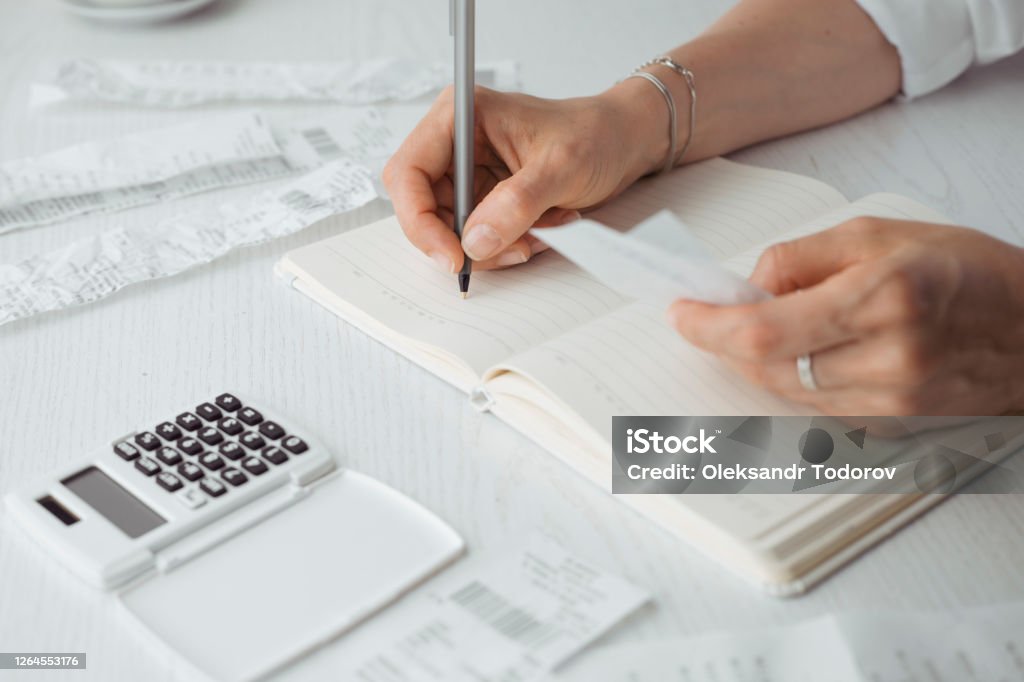 Counting on a calculator from a check and bookkeeping remotely. Bookkeeping Stock Photo