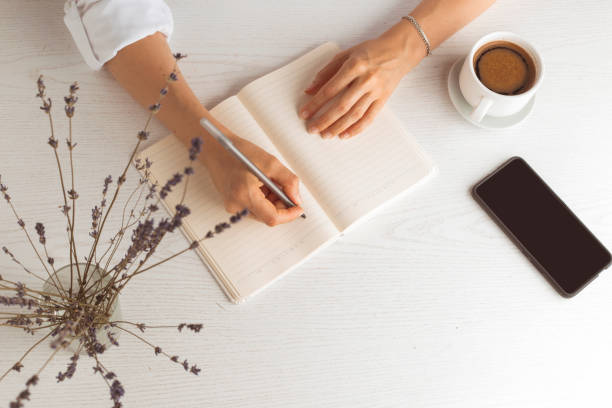 istock Woman's hands are writing in a notebook while sitting at home. 1264553291