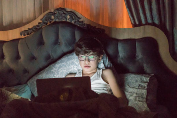 istock Teenage Boy Using Laptop In Bed At Night 1264553367