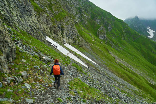 istock Lady hiker on a trail in the mountains 1264557922