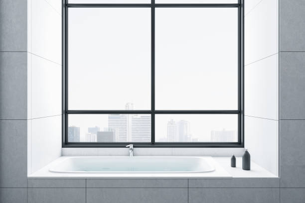 istock Clean bathroom interior with white bath and panoramic city view. 1264557945