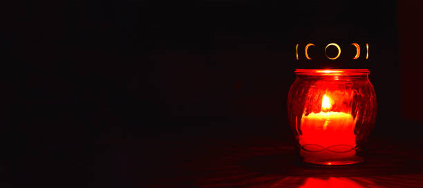 istock All Saints Day candle. Red votive candle on dark background 1264559677