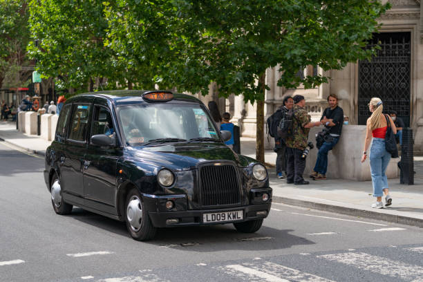 traditionelles schwarzes taxi taxi in london vor den royal courts of justice während des johnny depp-prozesses mit den paparazzi, die vor dem gericht warten - 197 - black cab stock-fotos und bilder