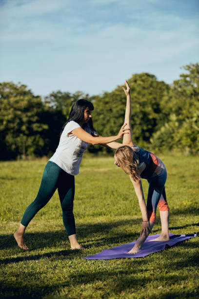 istock Pregnant woman doing yoga outdoors while her instructor showing her exercises. 1264572615