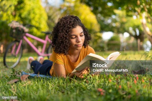躺在草地上看書的特恩女孩 照片檔及更多 讀 照片 - 讀, 少年男女, 書