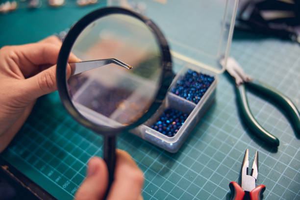 istock Hands of jewel maker zooming material element with a loupe 1264577985