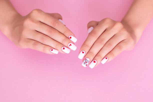 istock Beautiful female hands with white manicure, hearts design 1264578884