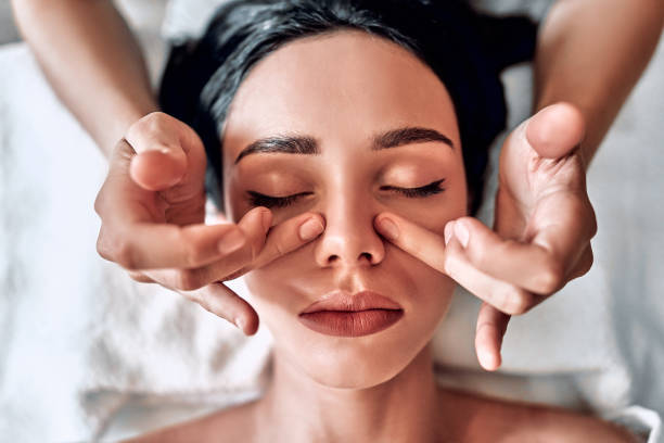 massage du visage. doigts de masseur. le nez et les mains se ferment. soins de la peau du visage. femme au salon de spa de beauté. - massagist photos et images de collection