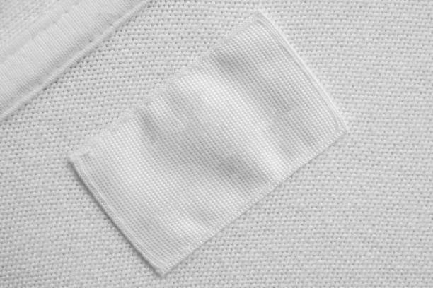 istock White blank laundry care clothes label on cotton shirt background 1264580498