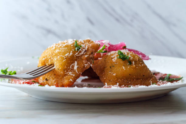 Breaded Fried Toasted Ravioli Breaded fried Italian ravioli topped with pickled red onions and grated pecorino romano cheese and hot marinara tomato sauce pecorino romano stock pictures, royalty-free photos & images