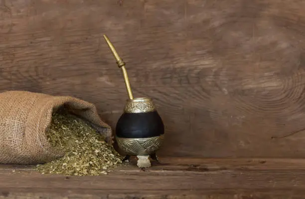 Mate and yerbamate on rustic wooden background. Traditional South American infusion