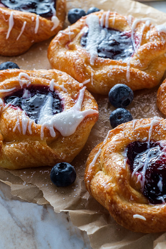 Blueberry glazed danish dessert pastries with icing and powdered sugar