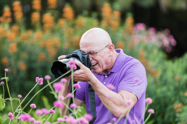 istock Mature man with camera, photographing nature 1264587449