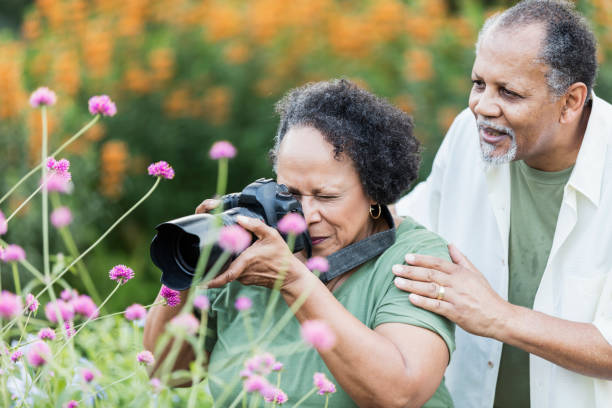 Senior couple in garden, woman taking photos