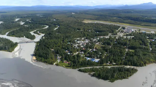 Small town of Talkeetna, lovely located at the confluence of Susitna (darker water) and Talkeetna (brighter water) Rivers, Central Alaska, USA. Downtown and the airport on the right side.